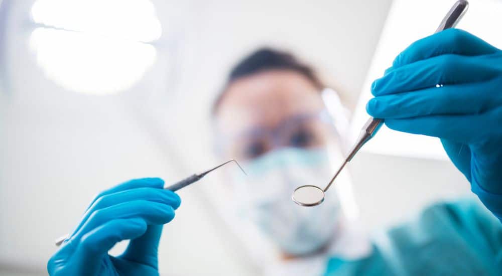 Gros plan d'un dentiste opérant un patient, faux dentiste, pratique illégale