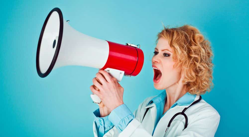 Médecin femme en colère criant dans un porte-voix