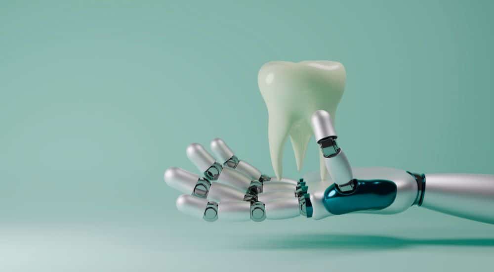 Main robotique tenant une dent. Développement de l’IA dans le domaine de la santé dentaire. Université d’été CDF 2025