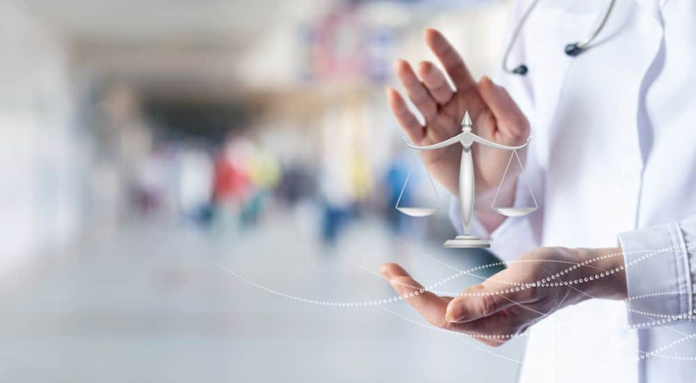 Un médecin montre la balance de la justice, loi sécurité pour les professionnels de santé