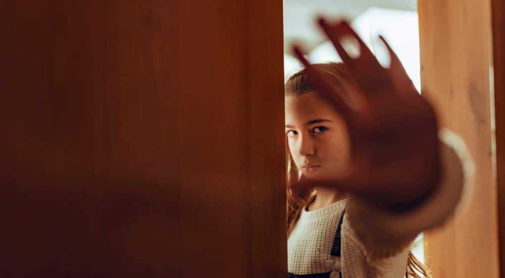 Petite fille triste faisant un geste stop avec sa main, outil d’accompagnement pour mineurs en danger