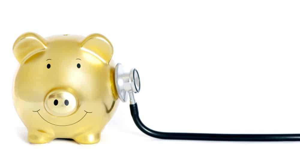 tirelire dorée en forme de cochon examinée par un stéthoscope, budget de la sante 2026