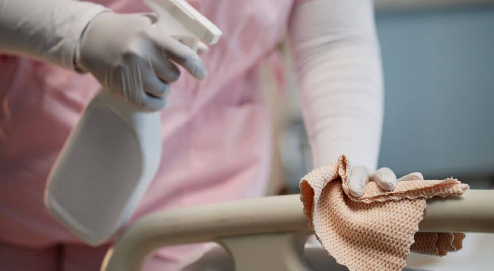 Nettoyage d'un lit d'hôpital avec un spray désinfectant et un chiffon, fin du certibiocide
