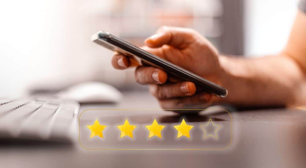 Un homme dépose un avis en ligne via son smartphone. Supprimer les avis Google concernant les chirurgiens-dentistes