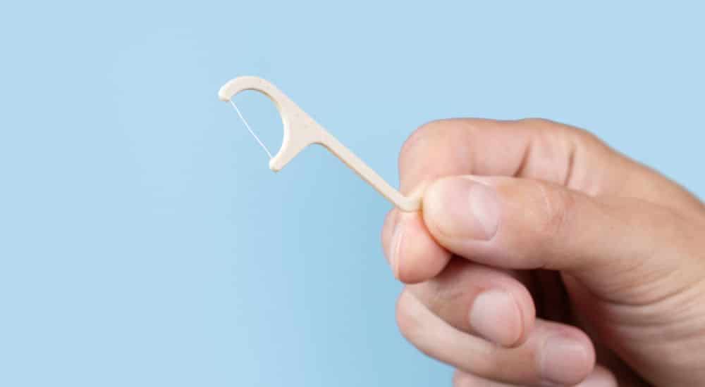 Homme tenant un fil dentaire dans la main, Vaccin sans aiguille