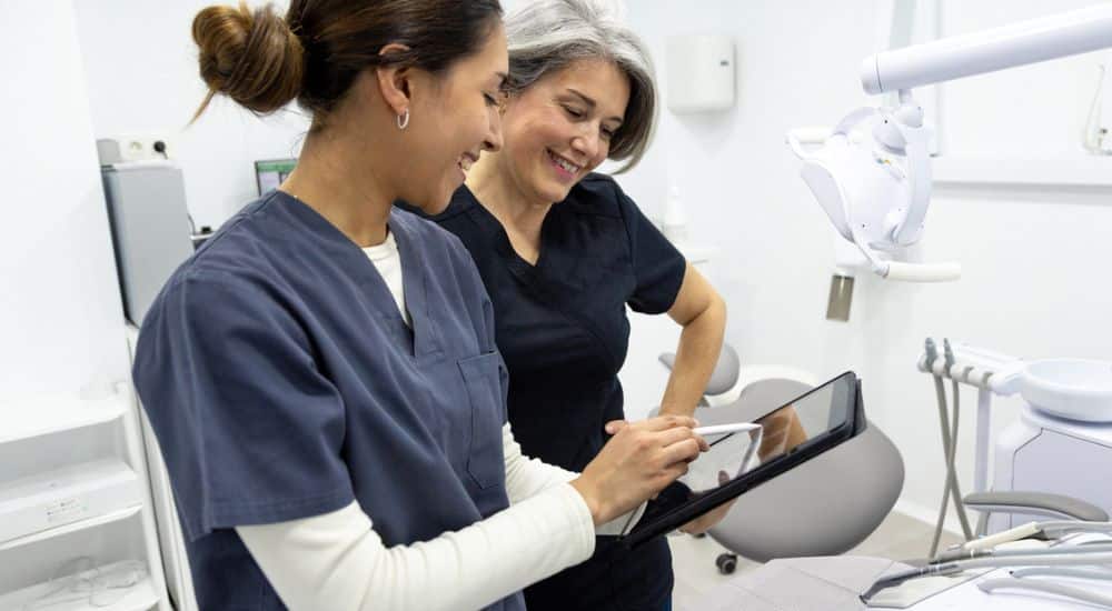 Femme dentiste et son assistante qui regardent une tablette numérique, Hand in Cab 2025
