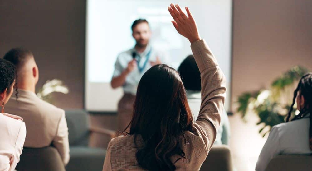 groupe enformation. Femme de dos levant la main pour répondre au formateur, suppression andpc