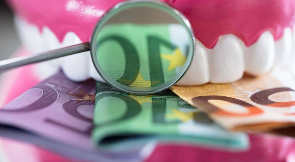 Gros plan de la prothèse avec des billets de banque, escroquerie aggravée orthodontiste Rouen