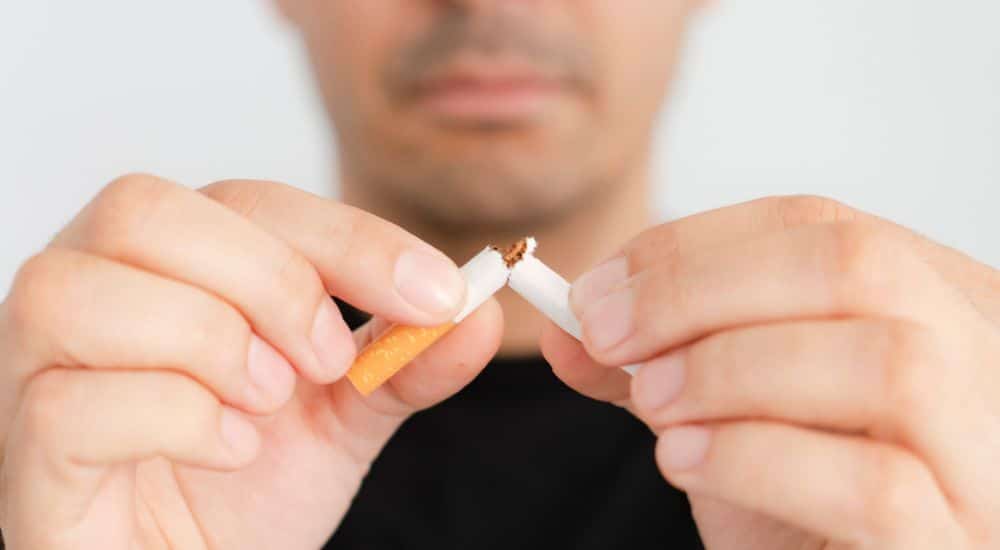 Homme cassant une cigarette en deux. tabagisme en France, chiffres 2026