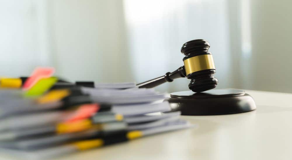 Pile de dossiers avec le marteau de la justice. Fraude à la CPAM