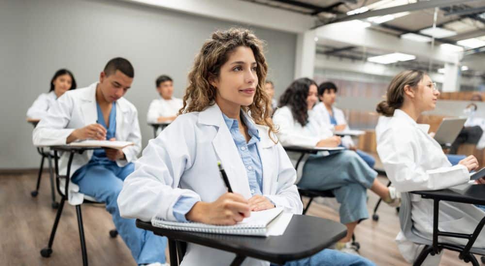 Groupe d’étudiants en médecine assis dans la salle de classe en train d’écouter une conférence,Réforme des études de santé