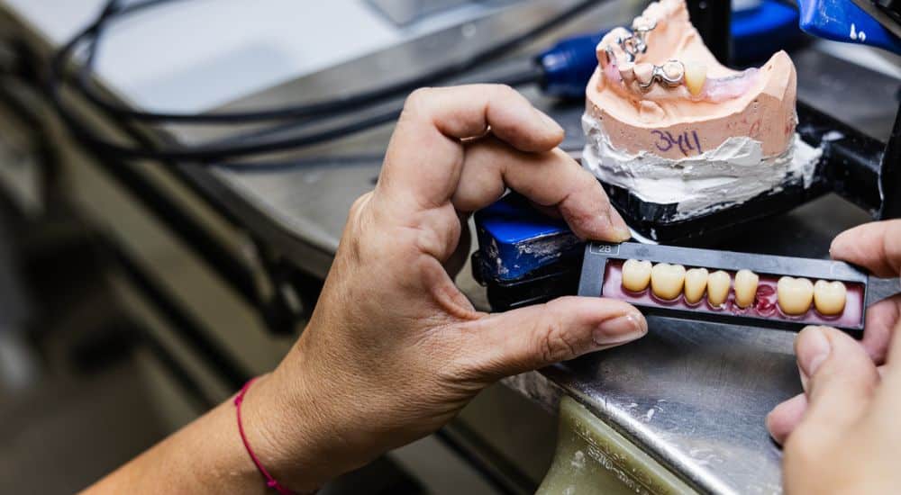 Gros plan d’un prothésiste dentaire examinant des prothèses dentaires, dentistes mis à pied à Nantes