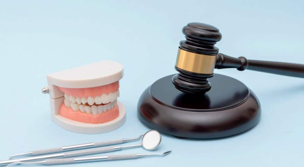 outils de dentiste et marteau de justice, exercice illégal de la chirurgie dentaire
