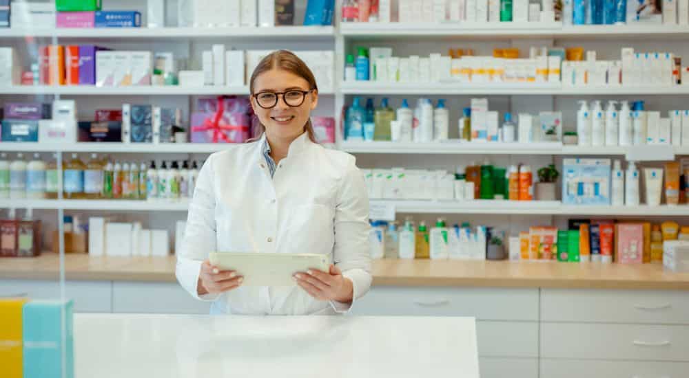 Pharmacienne devant un rayon dans une officine. Prescription traitement dentaire