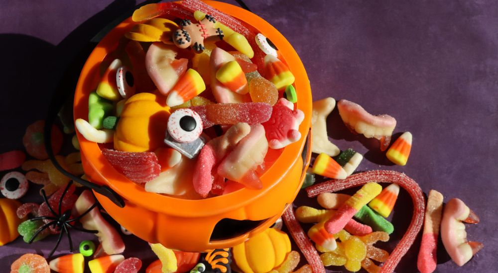 Gros plan d'un seau de bonbons d'halloween en forme de citrouille. Rachat de bonbons d’Halloween